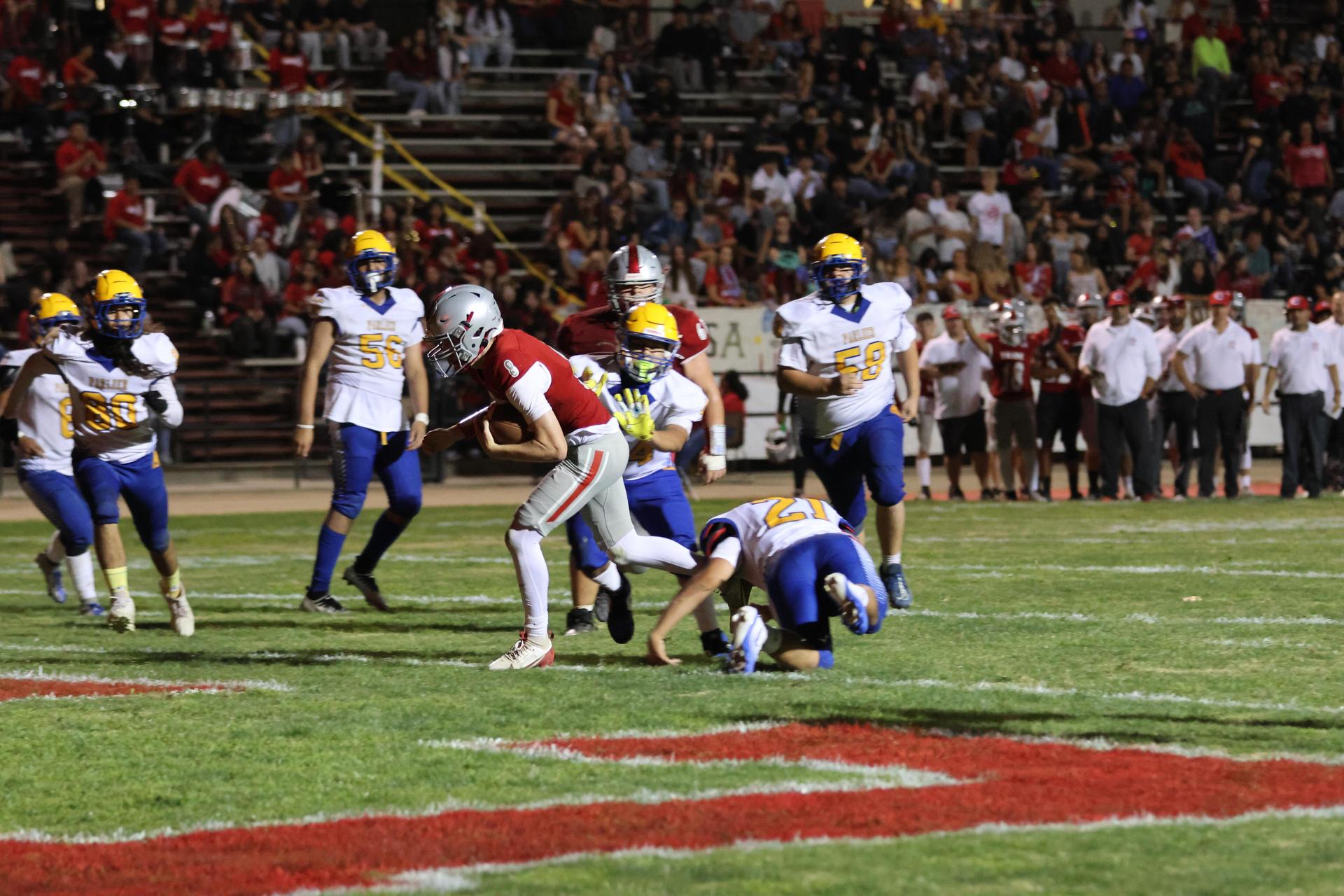 Varsity football players in action against Parlier 66