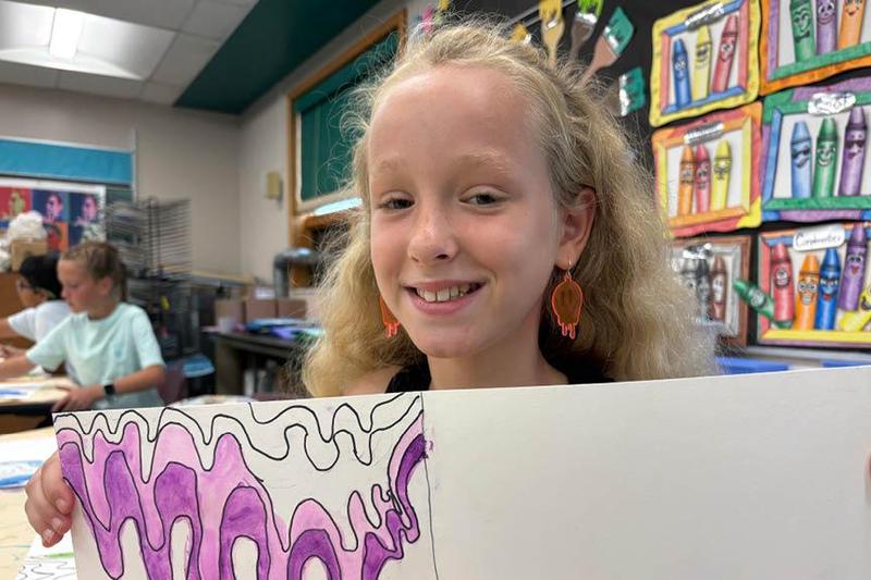 Rosalee Palko wears earrings that mimic the design of her artwork