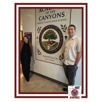 A woman and man standing near a sign for Academy of the Canyons Middle College High School