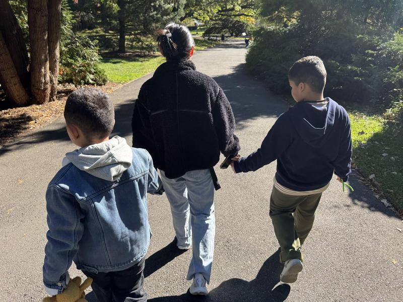 Two adults holding the hands of two students