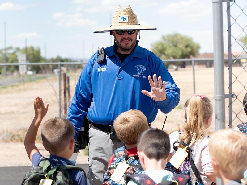 students giving high-fives to the school resource officer