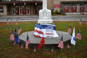 Banner commemorating West's support of DAV with American and service branch flags around it