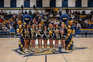 7 cheerleaders in a row between two balloon pillars