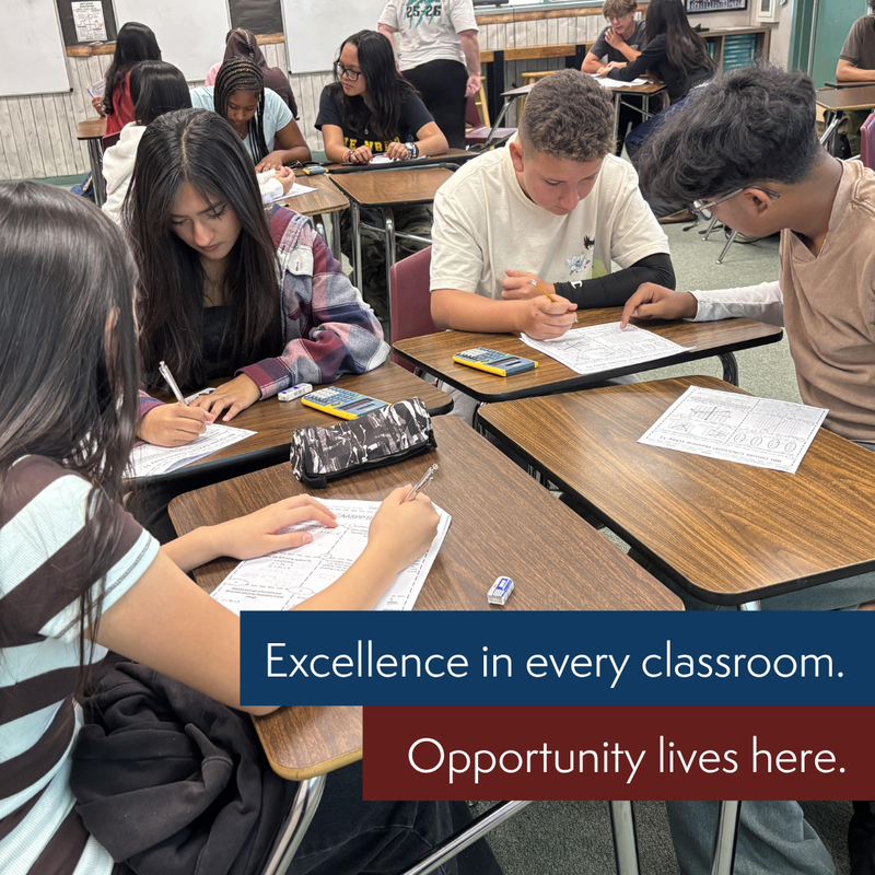 Students working in groups in a classroom.