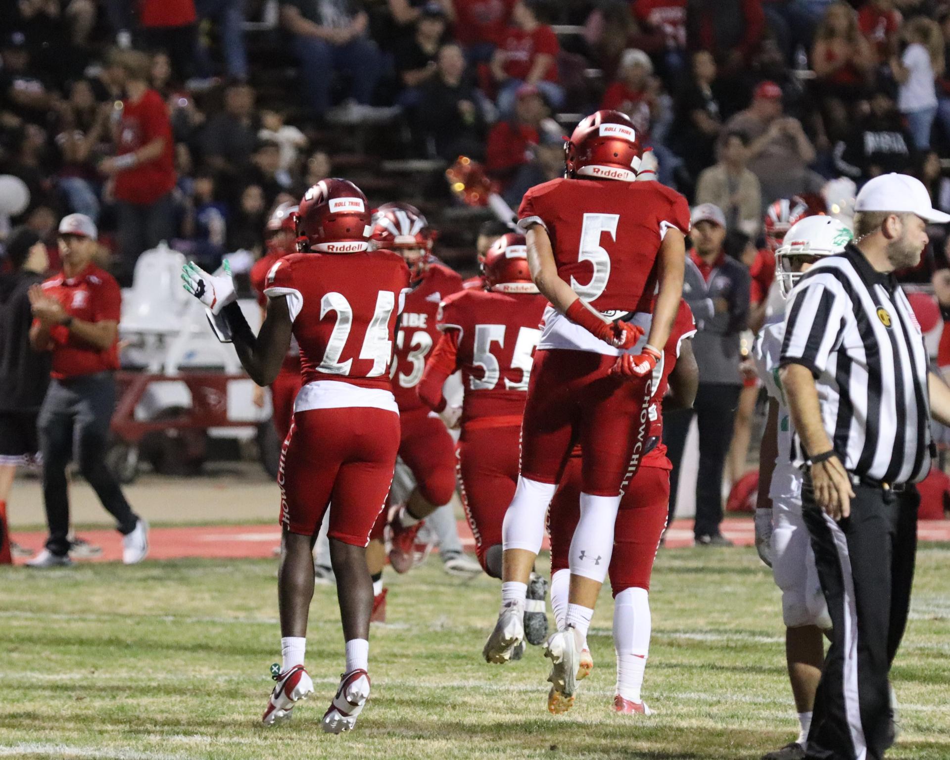 varsity football players in action against Riverdale