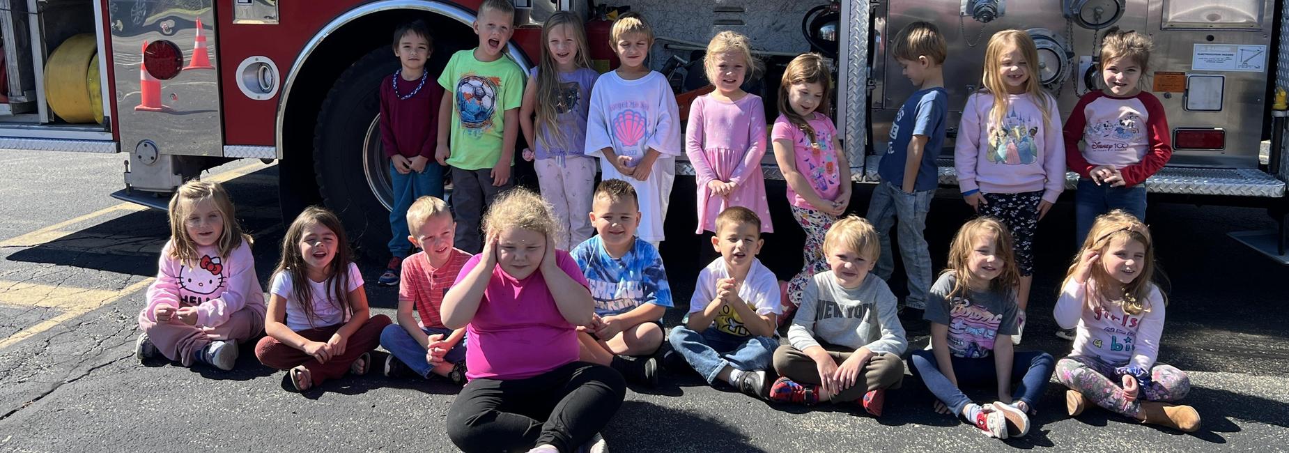 students posing in front of a fire truck