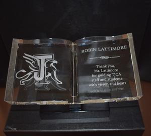 Crystal book-shaped award engraved with Robin Lattimore’s name and a message thanking him for guiding TJCA staff and students.