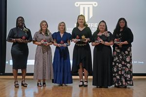 All six Teacher of the Year candidates pose with their trophies.