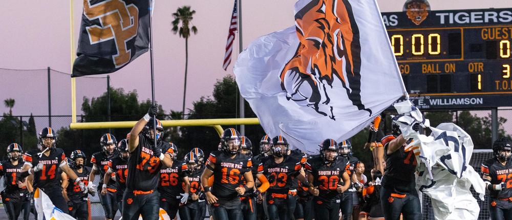 football players running on the field with flags