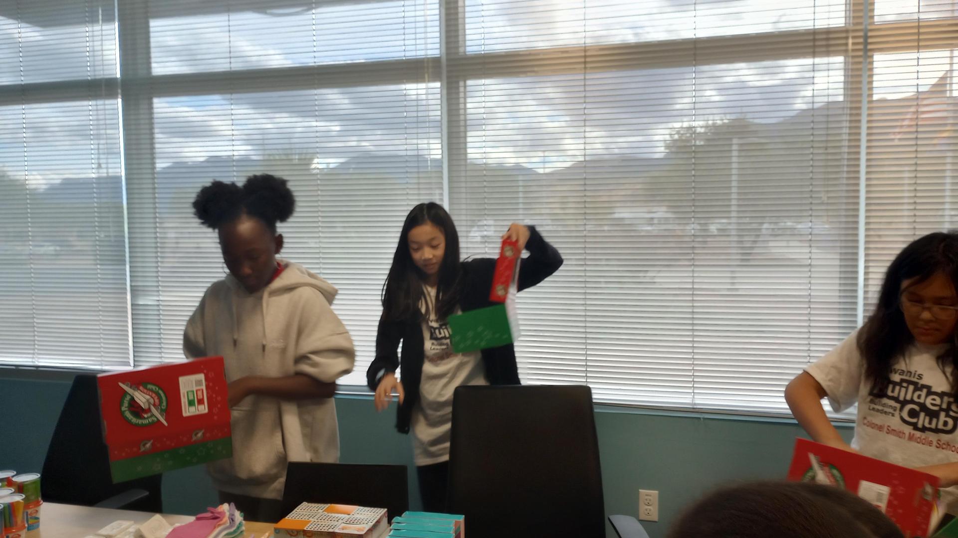 Two Kiwanis Club members pack holiday gift boxes.