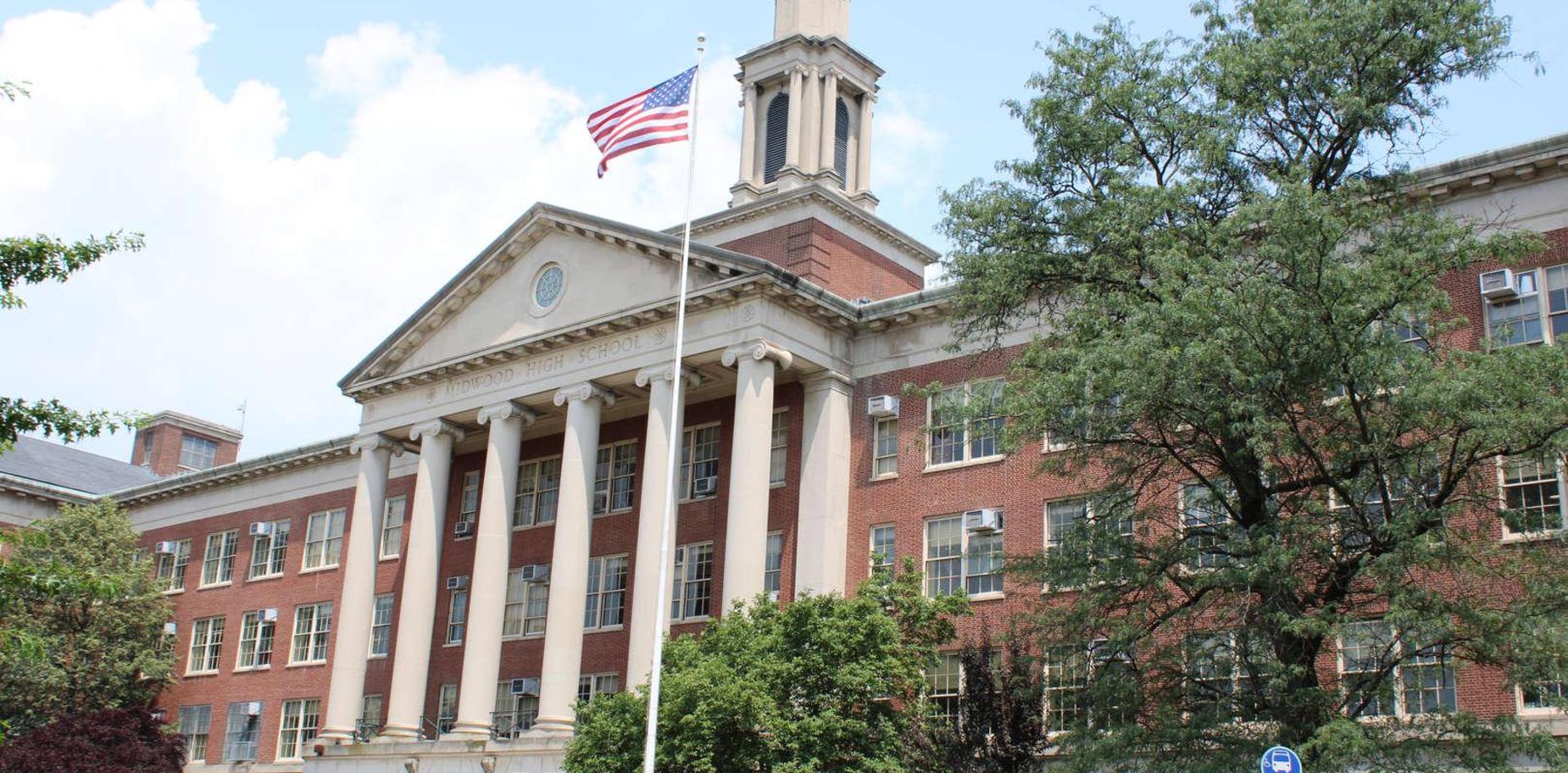 Historic brick building with columns and an American flag.