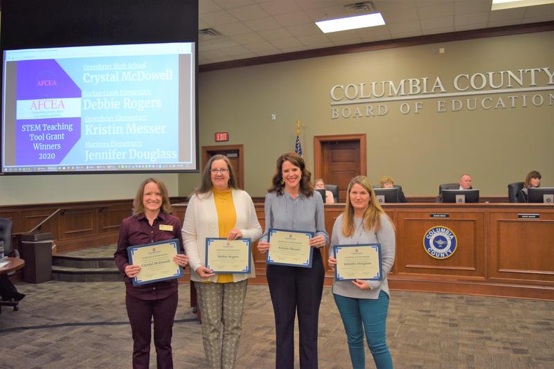 Teachers holding certificates and smiling