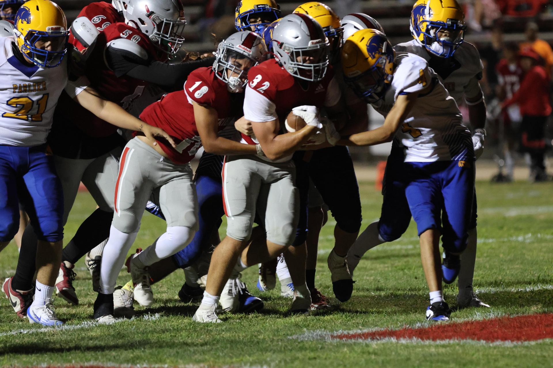 Varsity football players in action against Parlier 121
