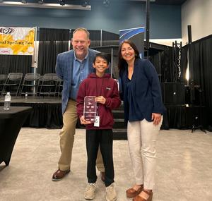 Terra Vista 7th Grader Wins Regional Spelling Bee, Zian Doctolero with principals holding up trophy
