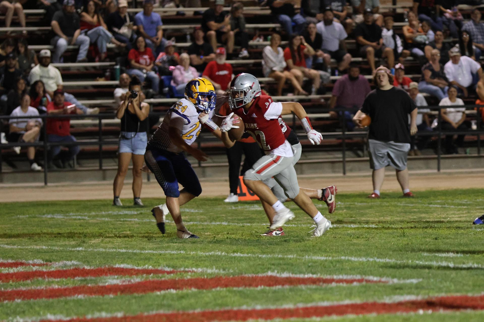 Varsity football players in action against Parlier 89