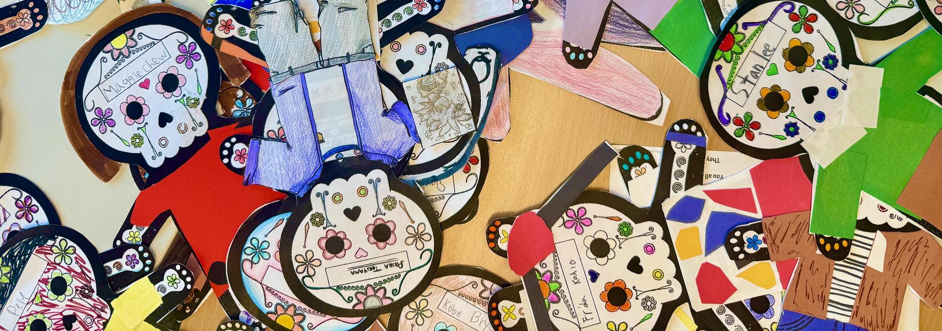 Colorful paper calaveras in various shapes, featuring drawings and designs.