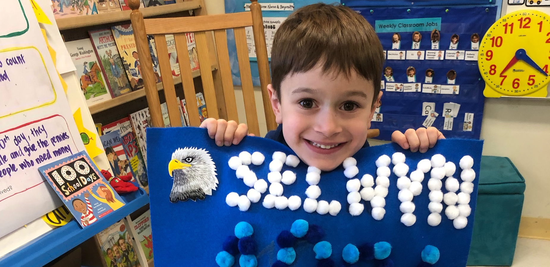 Kindergarten student holding 100th day project
