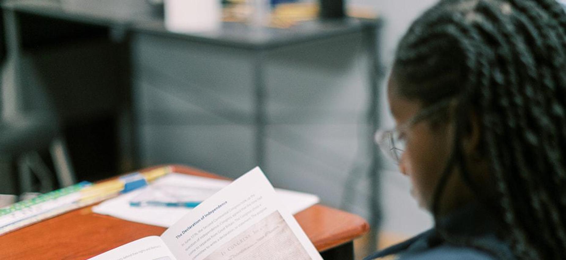 Student reads a book at her desk