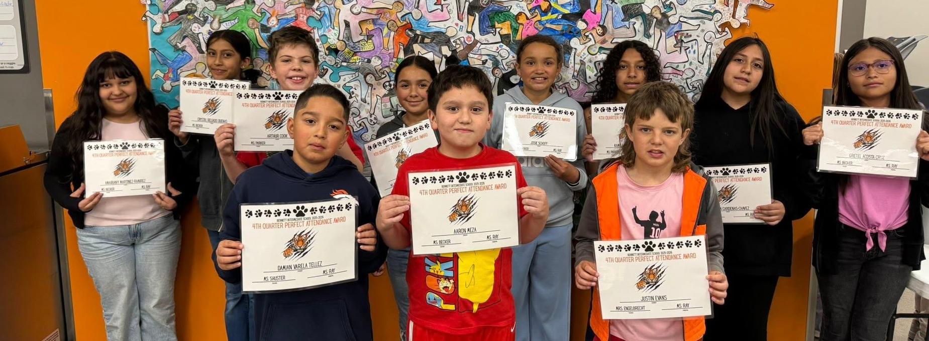 Students displaying certificates against a vibrant mural background.