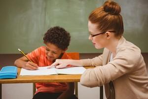  teacher working with student on a written assignment