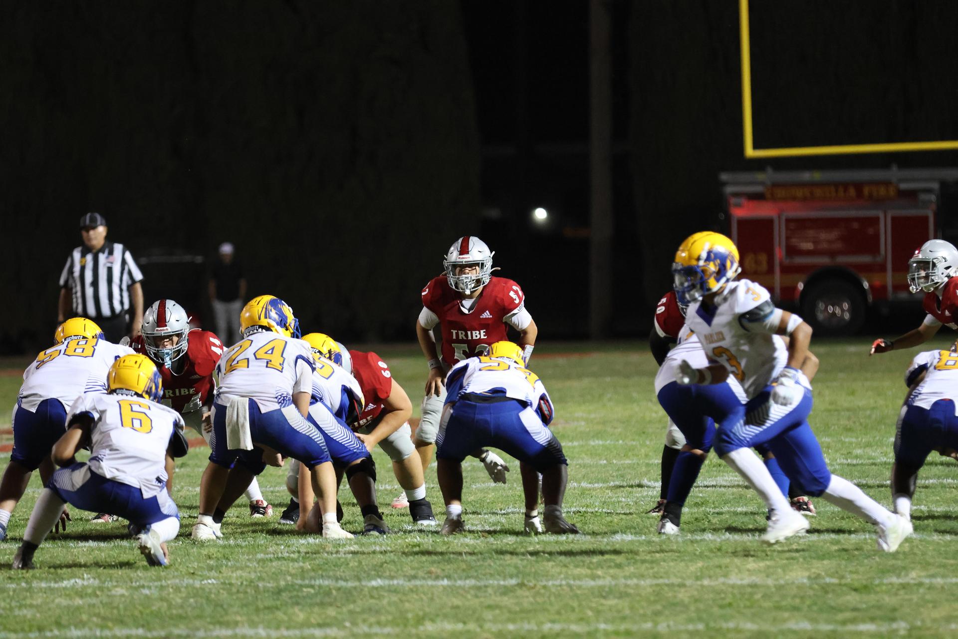 Varsity football players in action against Parlier 96