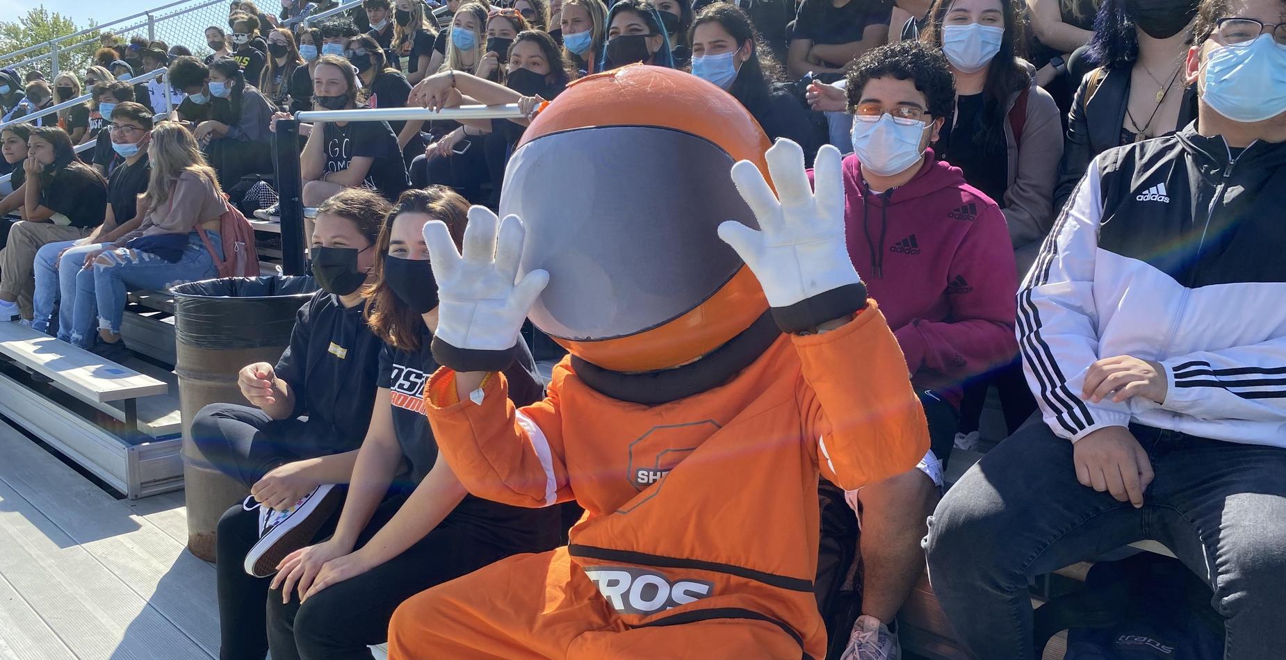Students and Astro Man watch the band perform during the 2021 Homecoming Pep Assembly.