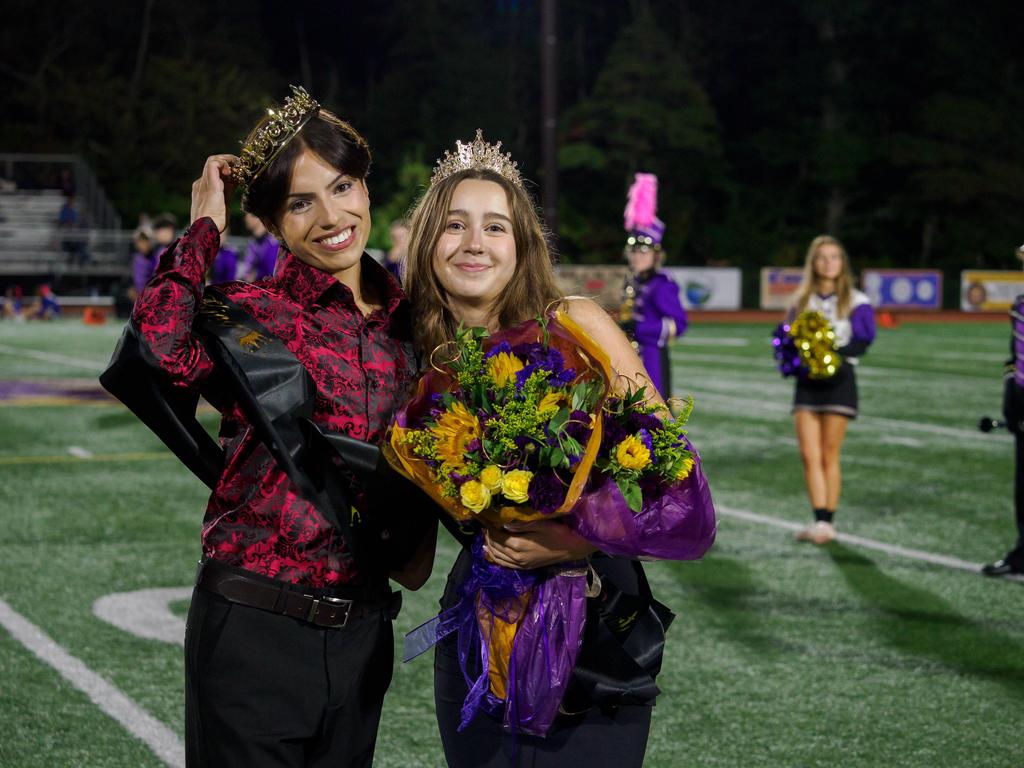 The Homecoming King and Queen with flowers and wearing crowns.