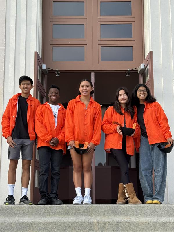 Five students posing in front of Anderson Auditorium
