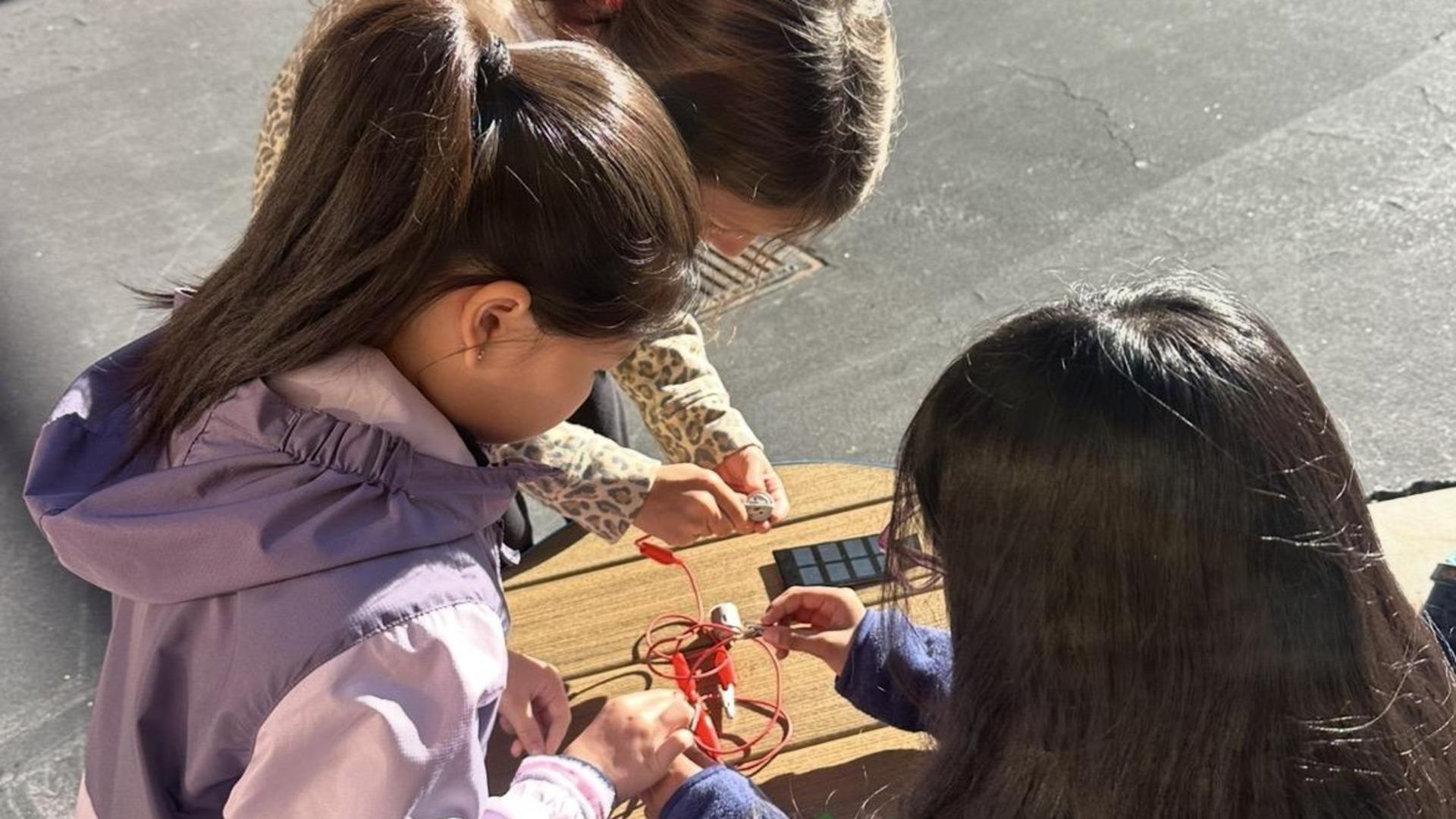 Three students creating a solar panel circuit.