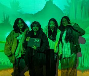 Four students holding a laser tag set they won