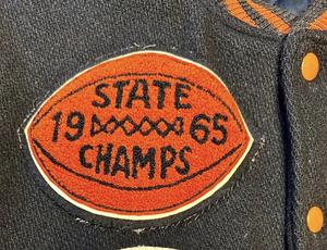 A letterman jacket with a 1965 State Champion patch.