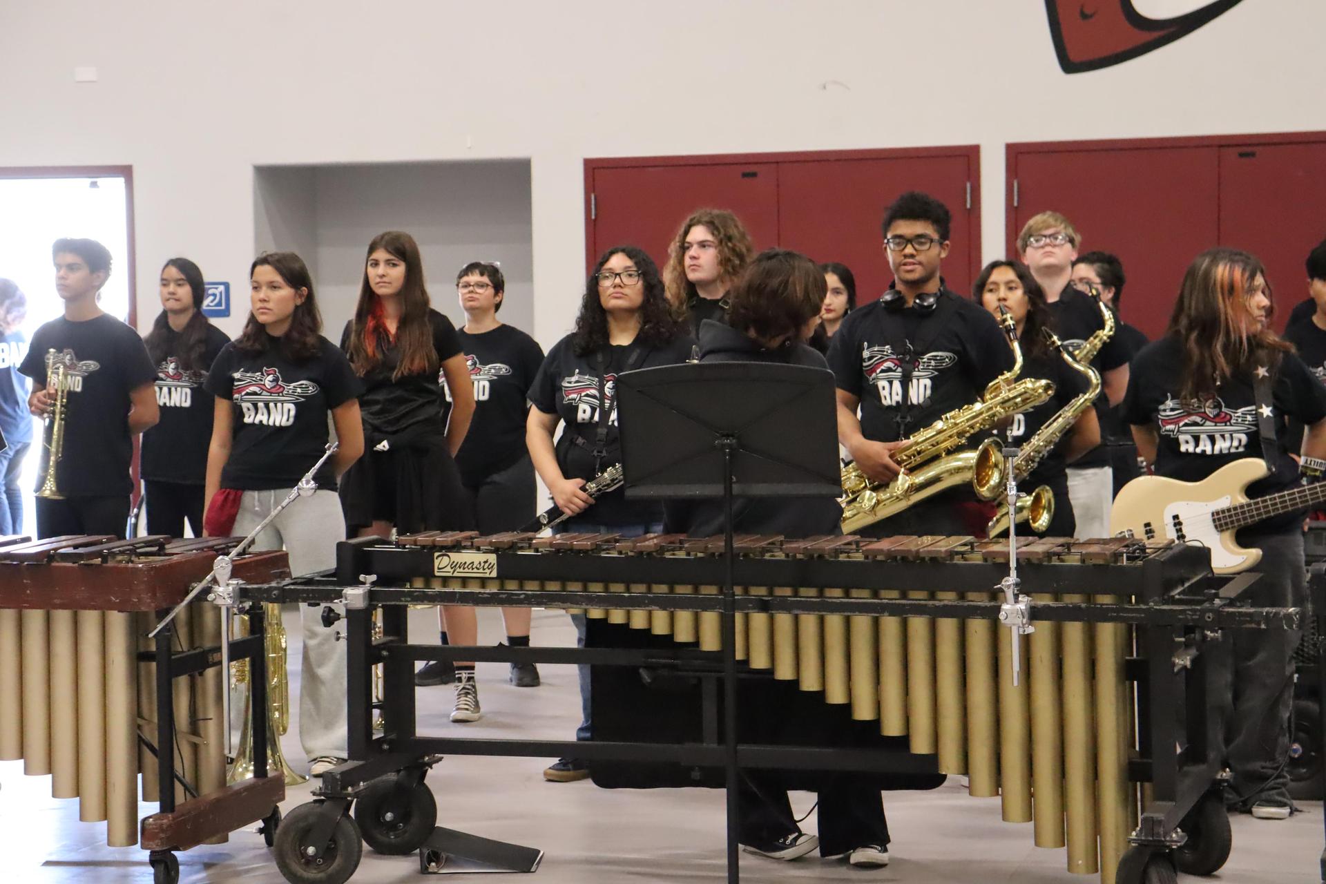 A group of students hold their instruments, preparing to play