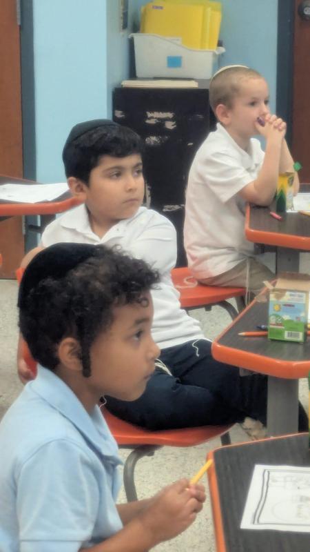 3 first grade boys listen to Rabbi Freuidlich