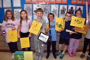 Six fourth-graders holding their inventions