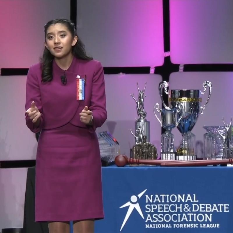 Student giving speech from stage at finals