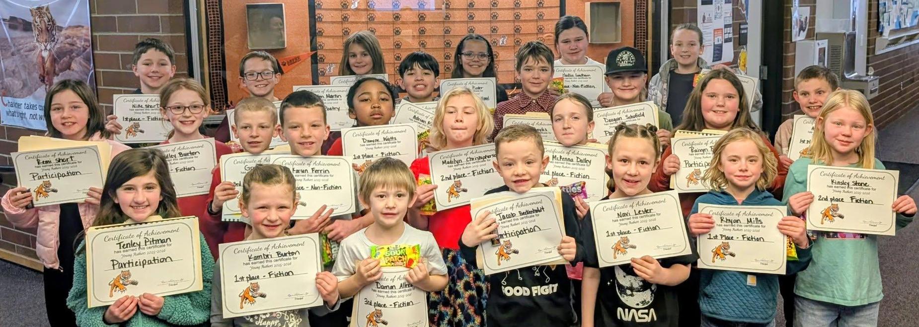 A group of children proudly display their participation certificates together.