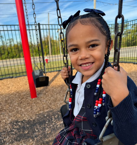 The LHS student is enjoying the playground, swinging.