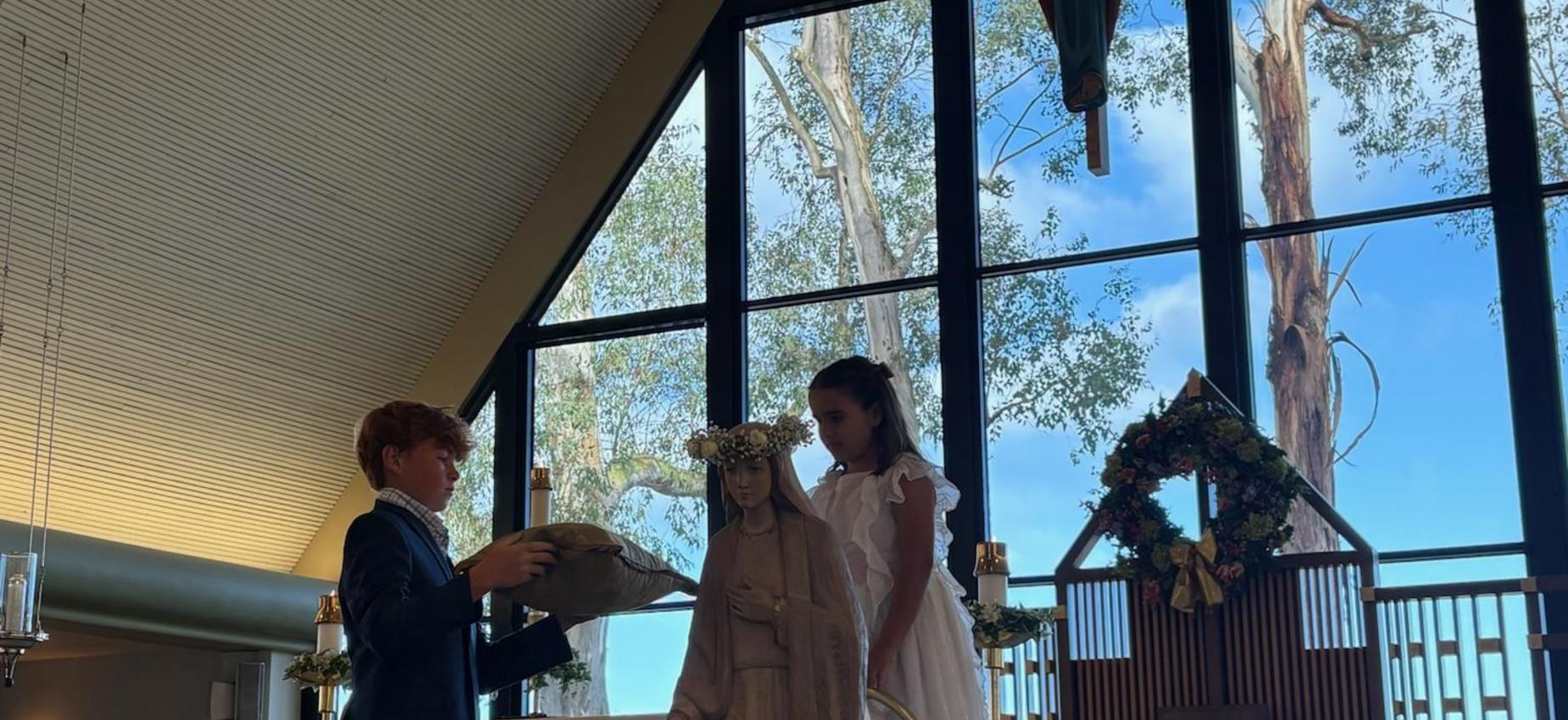 8th grade and Kindergarten student crown Mary at May Crowning Mass