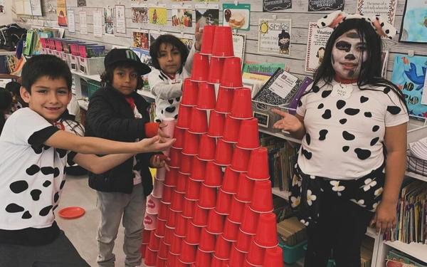 students displaying a stack of cups