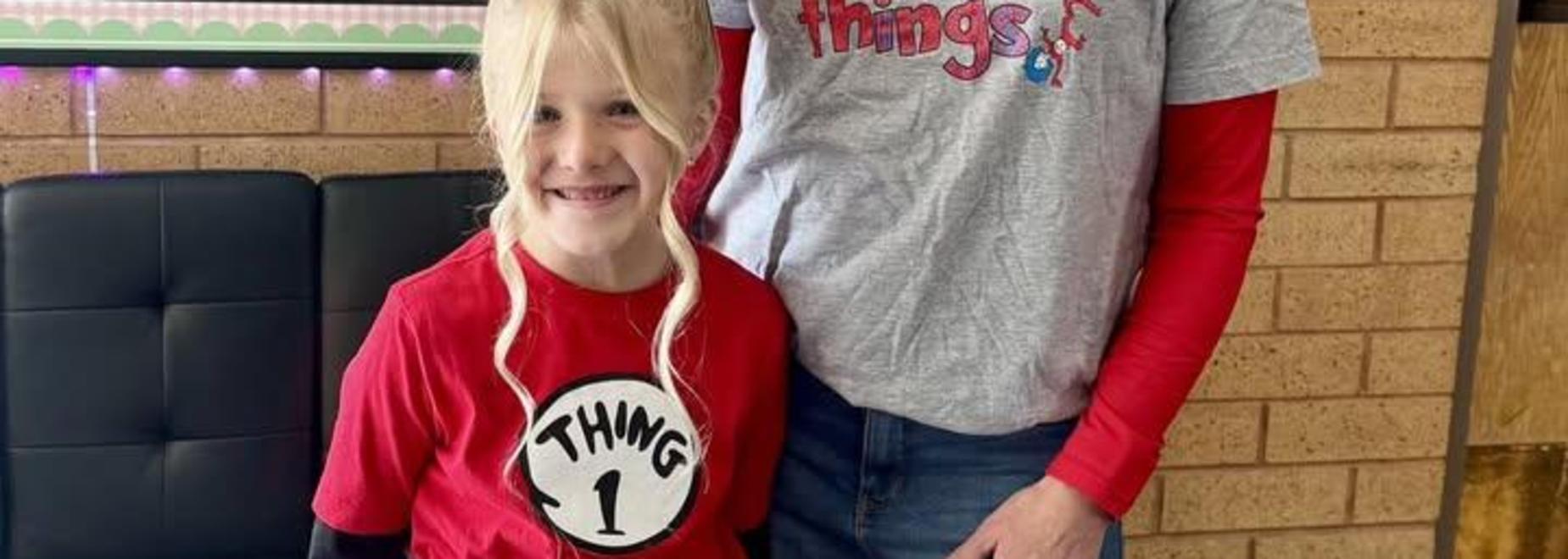 Two girls posing together, one wearing a 'Thing 1' shirt.