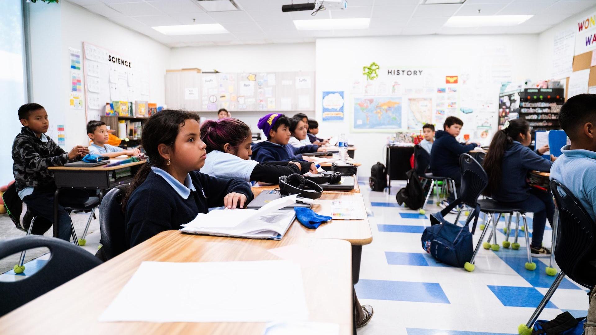 Students engaged in a classroom environment with desks and learning materials.