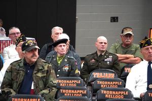 Veterans sit as guests of honor before the packed gymnasium.