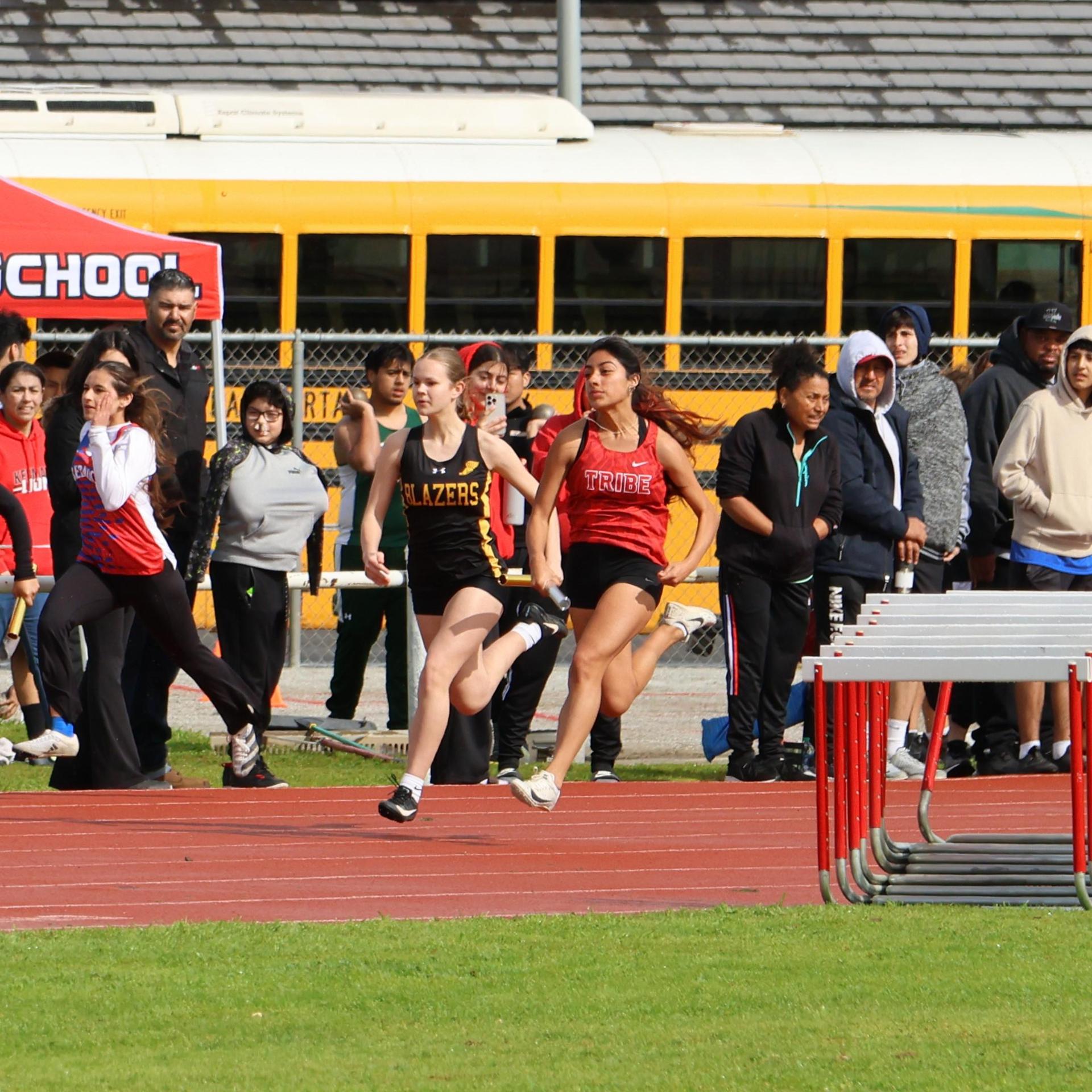 girls running the four by 100 meter relay