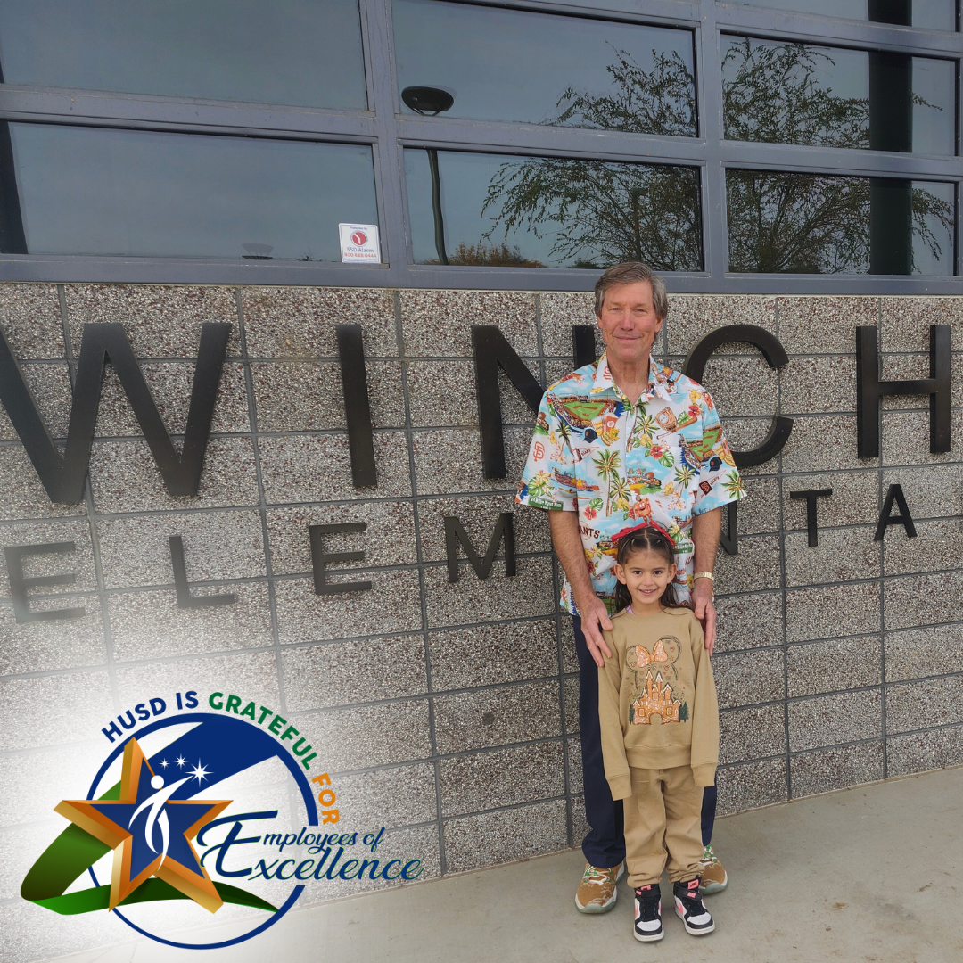 Harold is pictured in front of the Winchester School sign with his granddaughter.