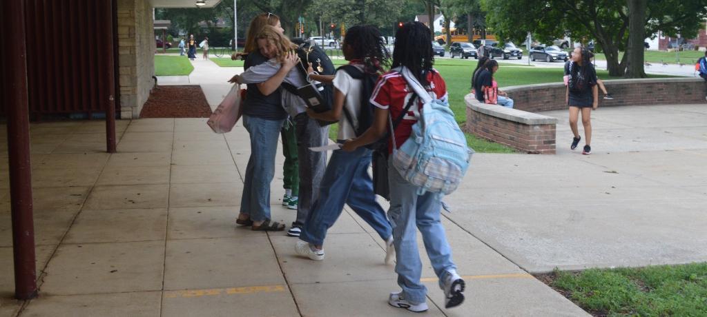 Teacher is hugged by student.