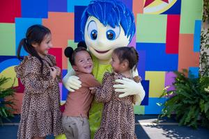 Joy hugs children at 70 Happiest Hours event.