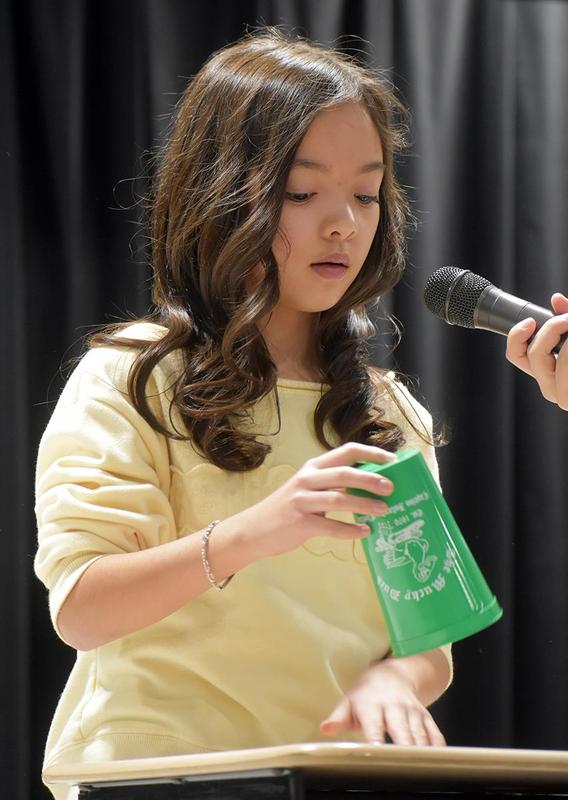 a girl singing whle playing with a cup