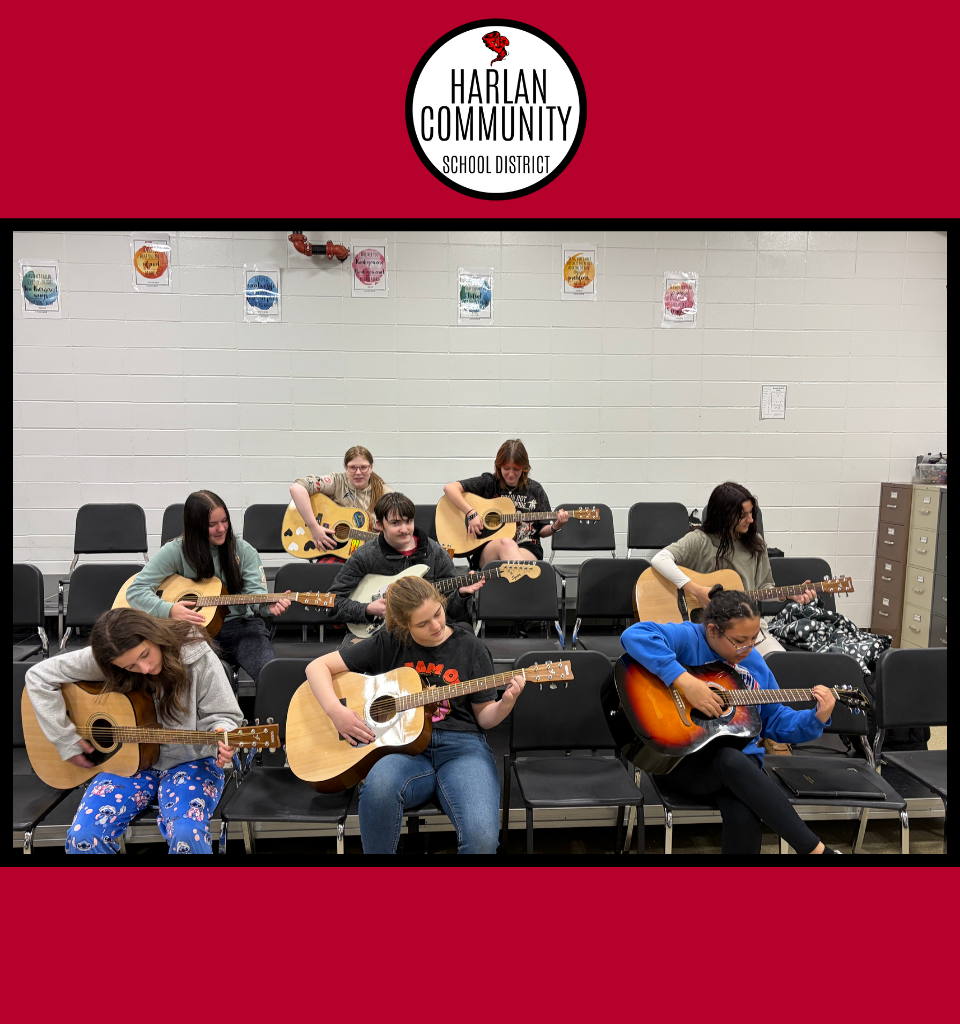 Students playing acoustic guitars in a classroom setting.