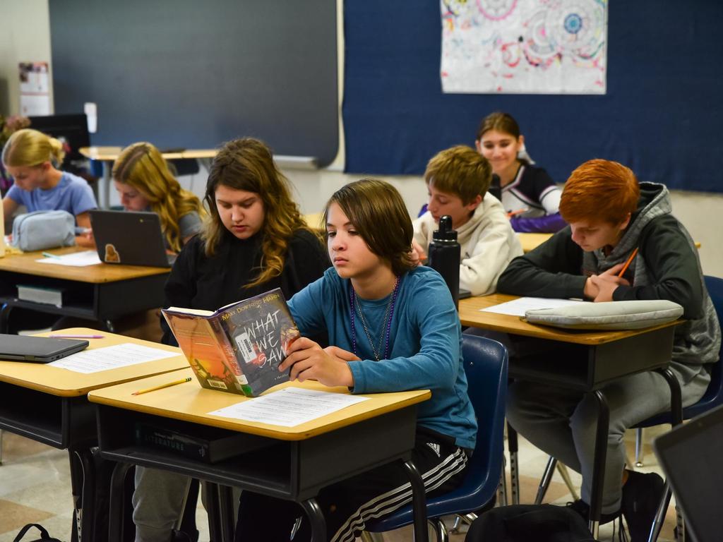 Students reading at their desks in a classroom.