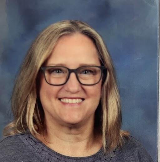 Rachel Harris wearing glasses and smiling in a school picture setting